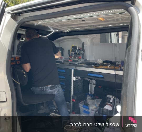 אדם עובד בתוך רכב עם כלי עבודה לנעילת רכב